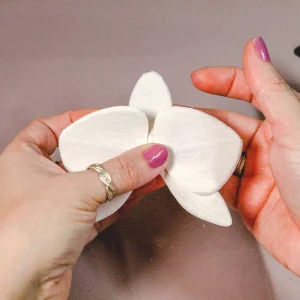 proceso artesanal de una flor de papel.