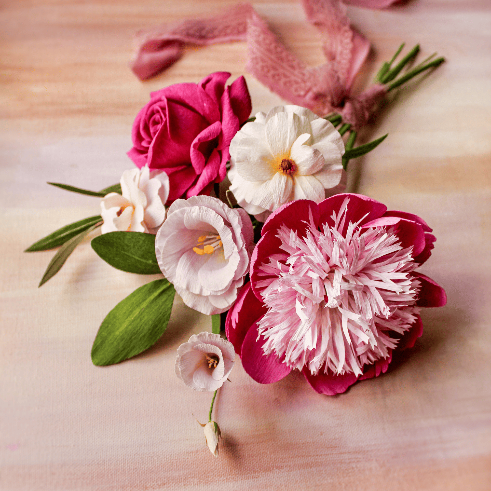 bouquet de flores de papel crepé artesanal en tonos rosados y blancos con hojas verdes