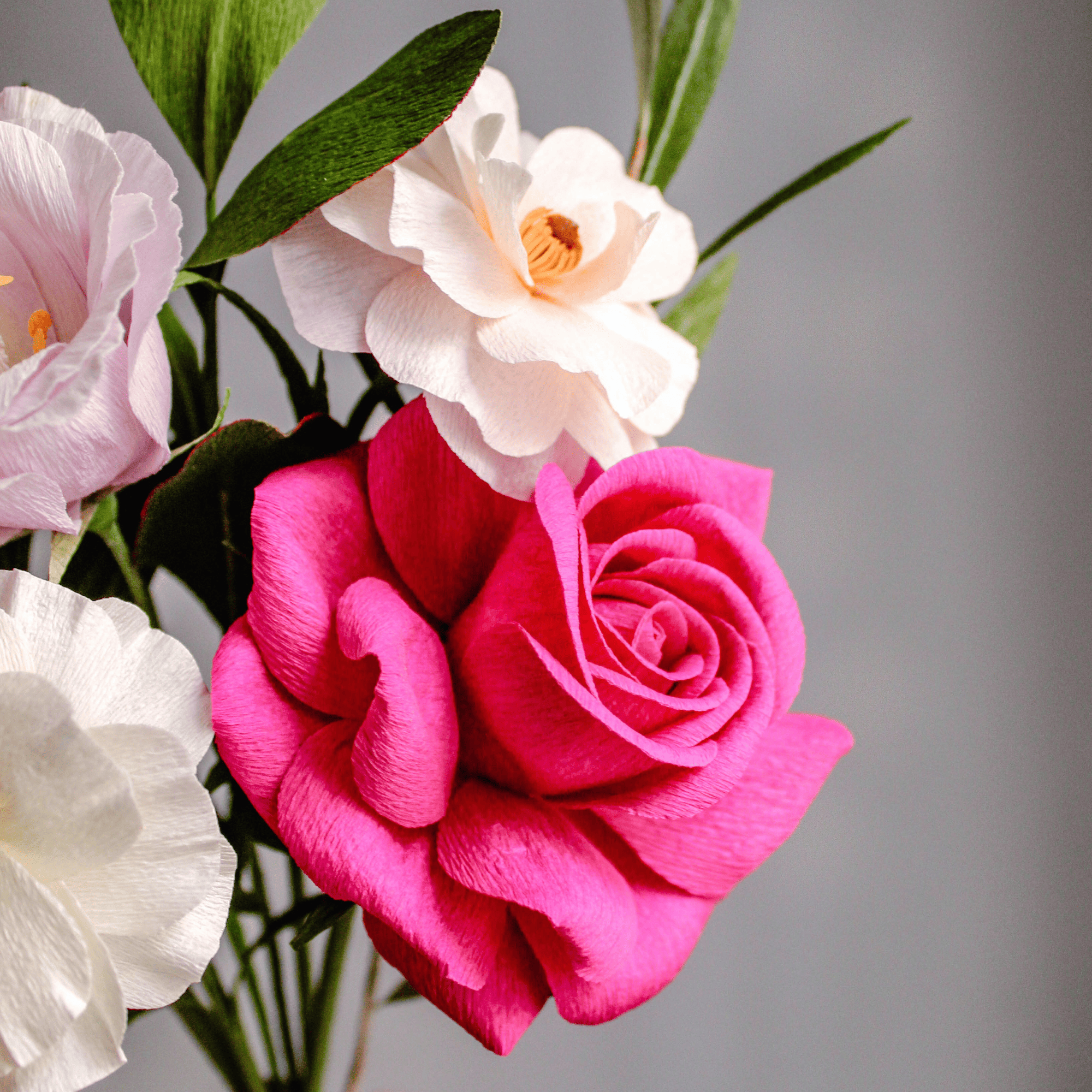 ramo artesanal de flores de papel crepé con rosa fucsia y flores rosadas para decoración o boda