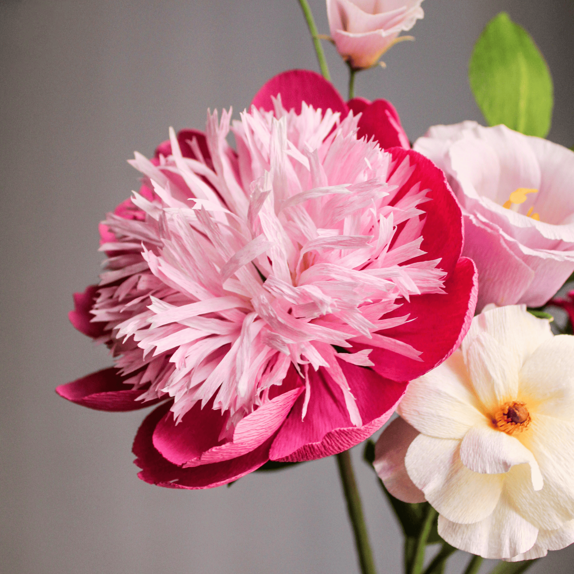 flores de papel crepé hechas a mano formando un bouquet en tonos rosa y blanco