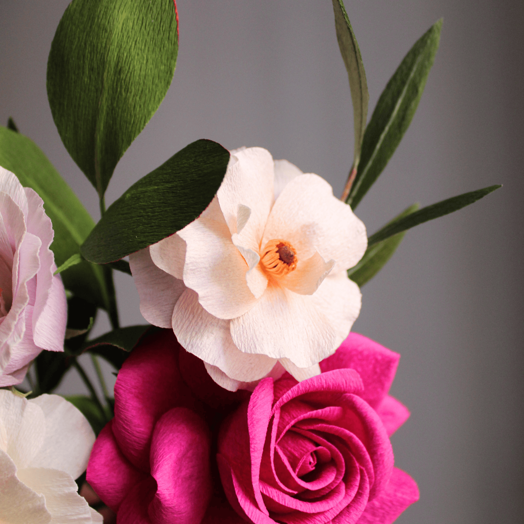 flores de papel crepé hechas a mano formando un bouquet en tonos rosa y blanco